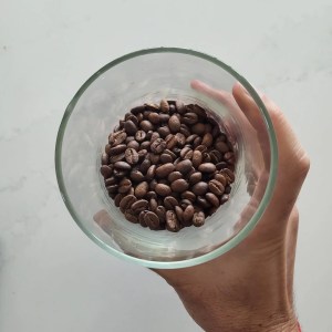 Whole coffee beans in a glass jar.